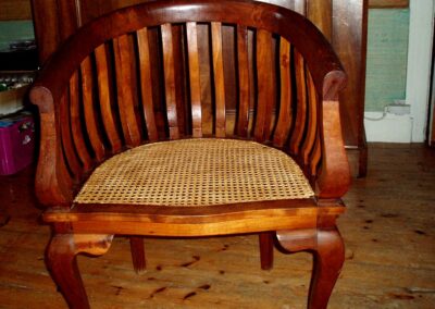 Fauteuil ancien en bois verni dont l'assise a été recannée en rotin naturel