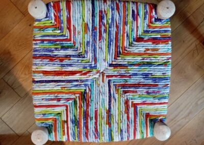 Assise carrée retissée à la main en bandes de coton multicolores, vue de dessus