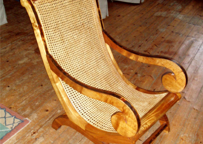 Chaise longue en bois clair au dossier et à l'assise cannés en rotin naturel