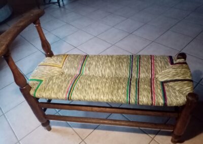 Artisane rempaillant une chaise en laîche, vue de l'atelier